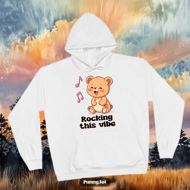 Funny hoodie showcasing a delighted bear cub interacting with a musical note, for cozy music fans.