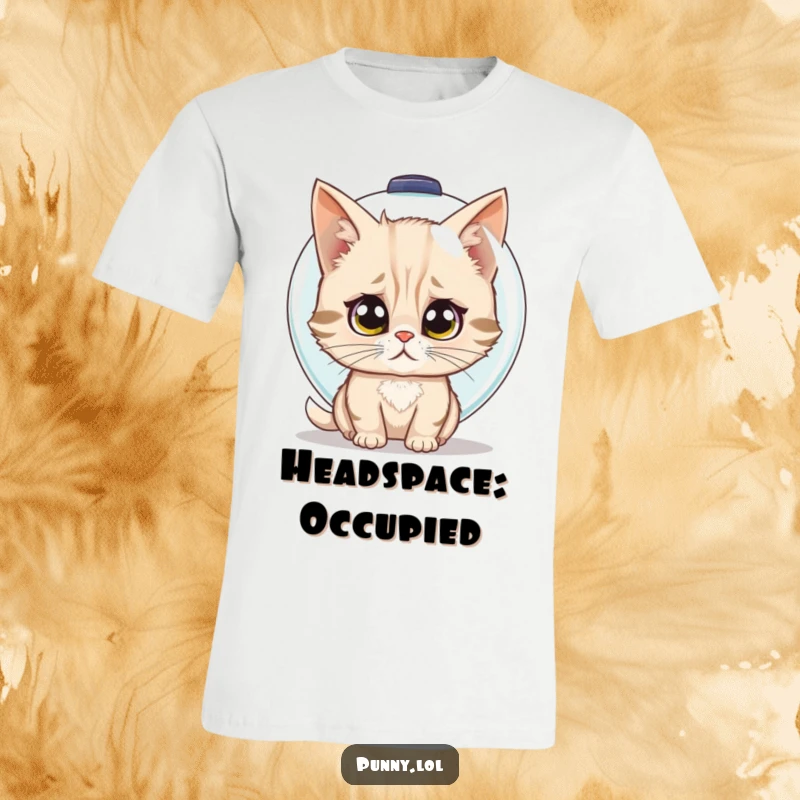 Funny t-shirt depicting a confused cat trying to wear a fishbowl as a helmet with wide, bewildered eyes.